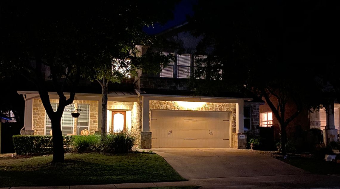 A cozy house illuminated at night, complete with a garage, creating a welcoming nighttime scene.